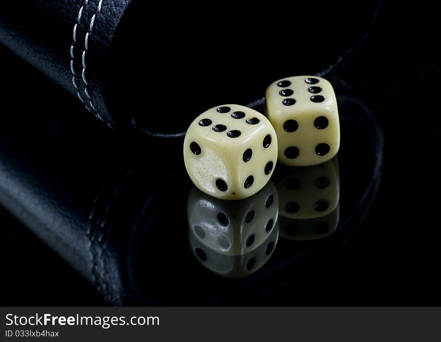 Two standard six-sided pipped dice with rounded corners on black background. Two standard six-sided pipped dice with rounded corners on black background.