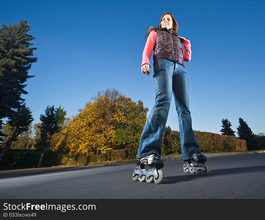 Wide-angle shot of a happy rollerblading girl