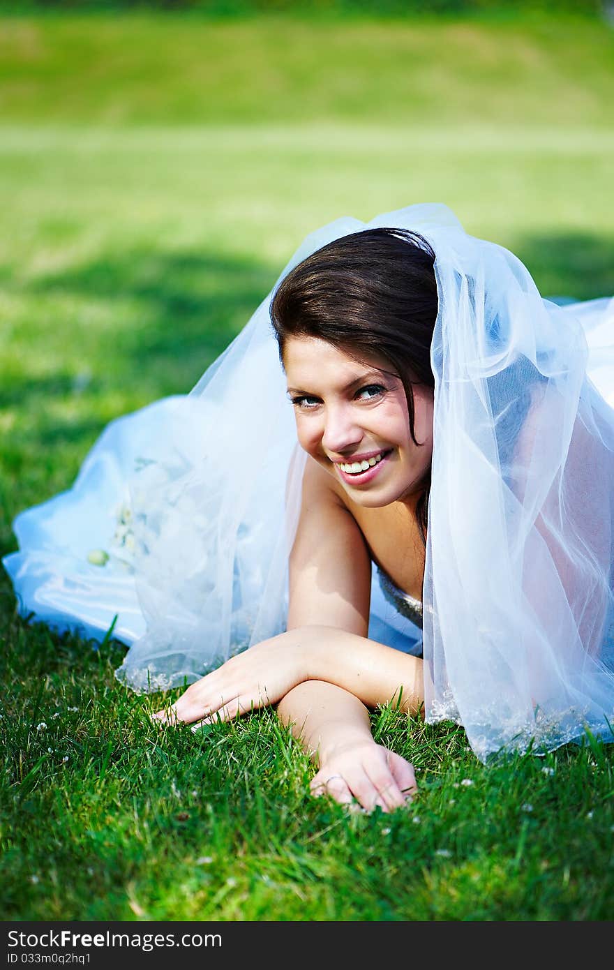 Fanny bride on the grass in the summer park