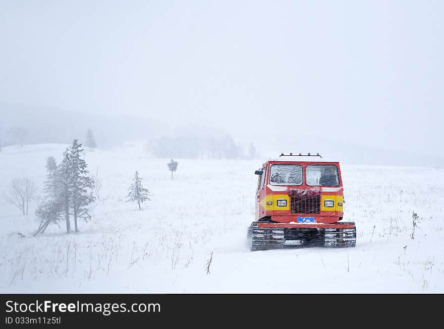 A marching tractor goes in the snowstorm. A marching tractor goes in the snowstorm