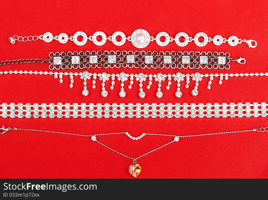 Women's bracelets and a necklace on a red fabric background