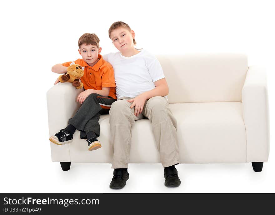 Two brothers sitting on a sofa on a white background