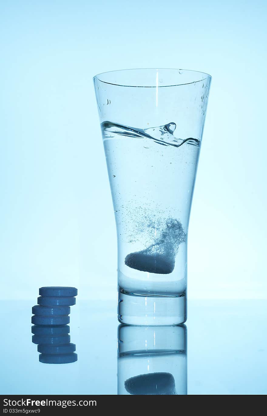 Glass with liquid and tablets. Glass with liquid and tablets