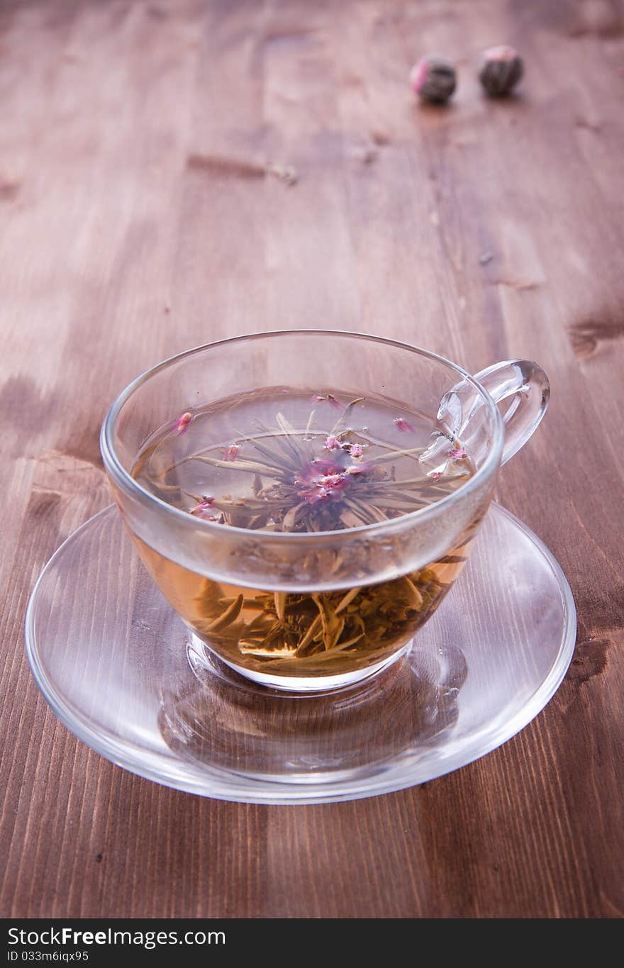 Transparent cup of green tea on the wooden table