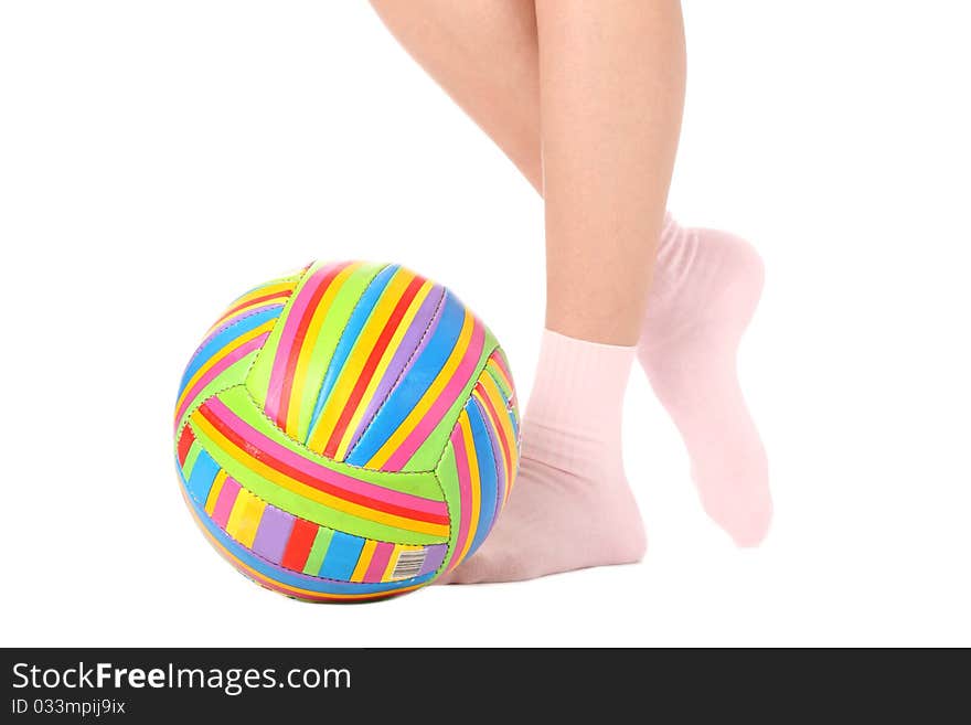 Close-up of human legs with a multicolored ball isolated on white