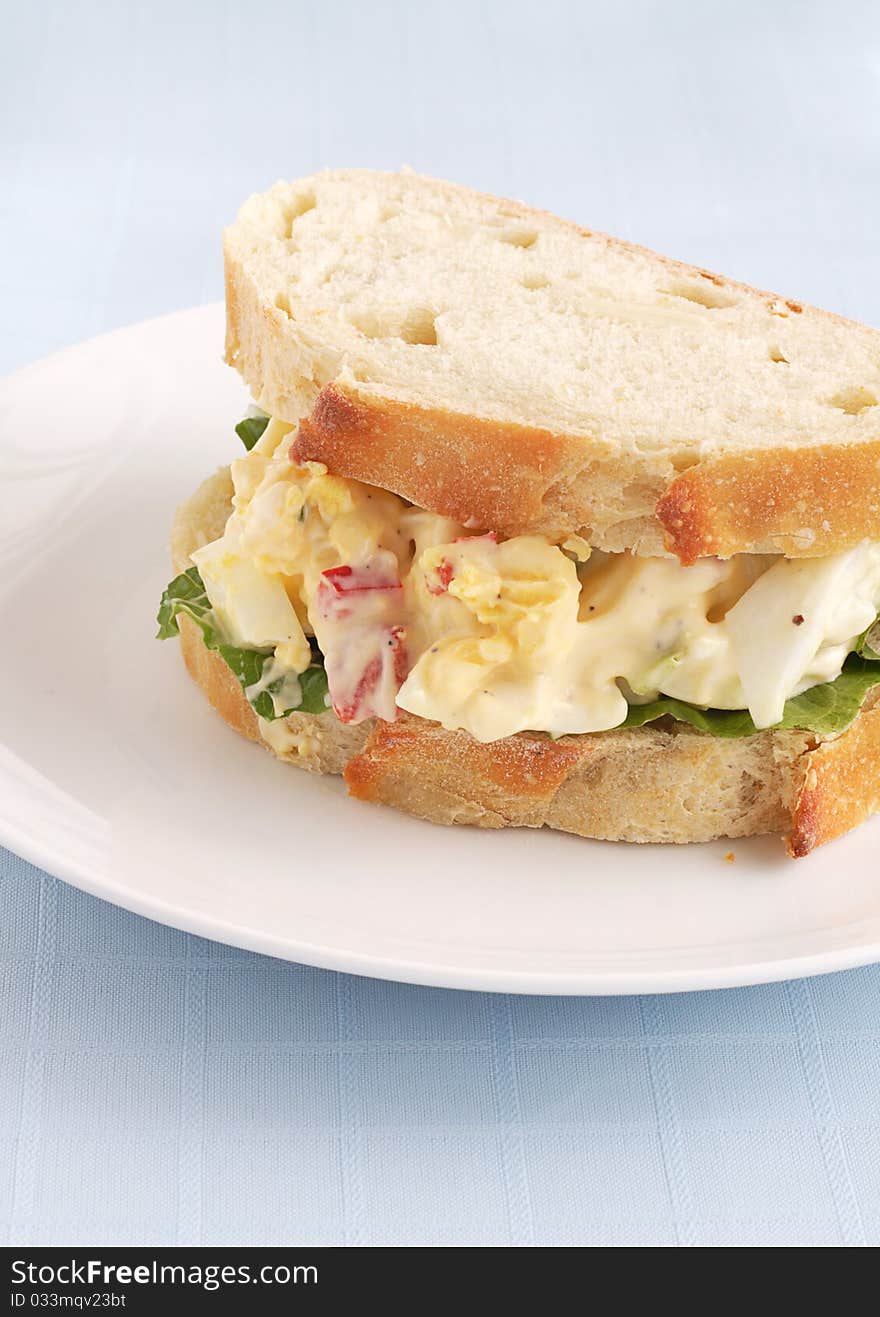 Yummy egg salad sandwhich on a bed of lettuce nestled between two slices of organic garlic bread. Yummy egg salad sandwhich on a bed of lettuce nestled between two slices of organic garlic bread