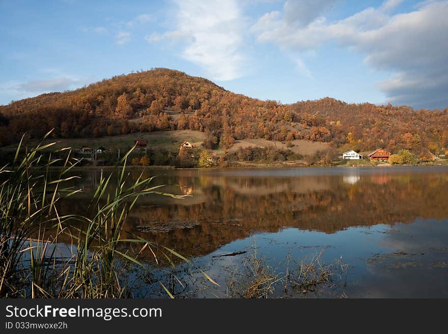 Very nice autumn day with a still pond and blue sky with some clouds and water reflections. Very nice autumn day with a still pond and blue sky with some clouds and water reflections