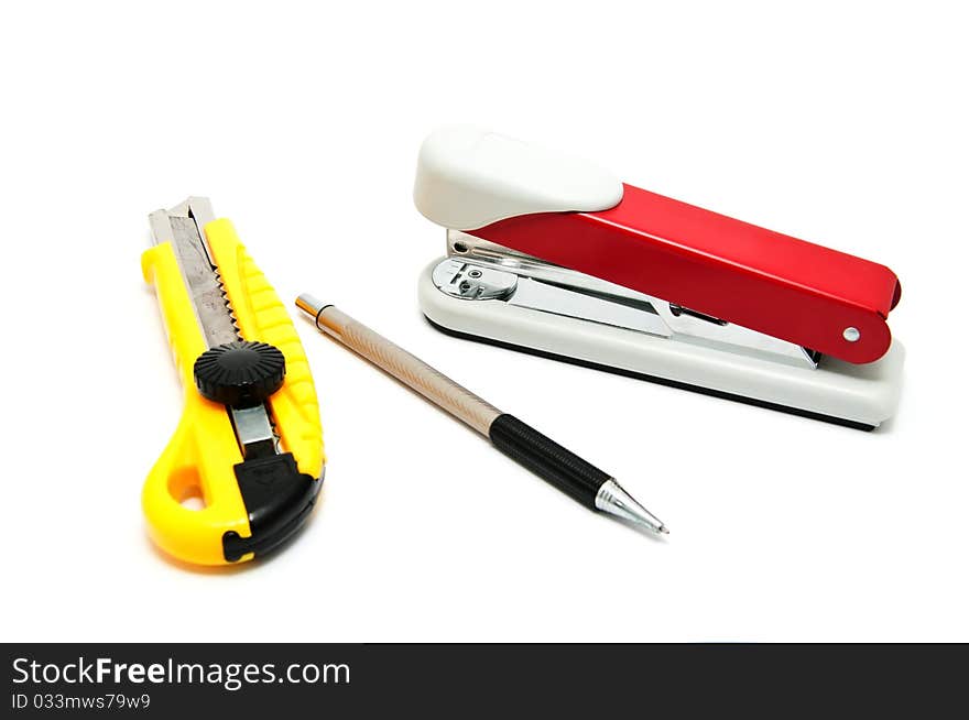 Several Office devices on a white background (stapler, knife, pen)