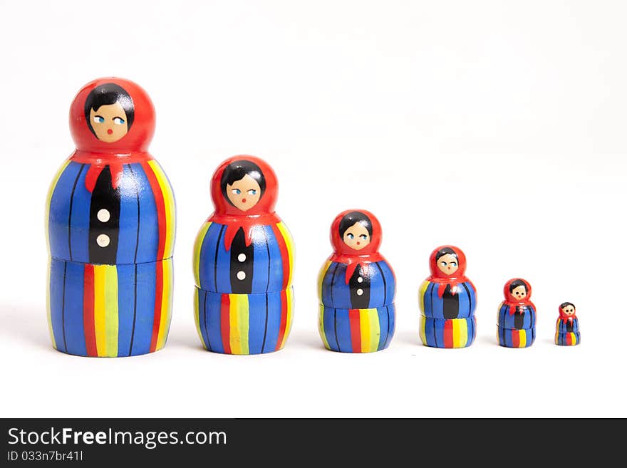 Russian matryoshka dolls in a line. Lots of wooden dolls, decreasing in size in a line.