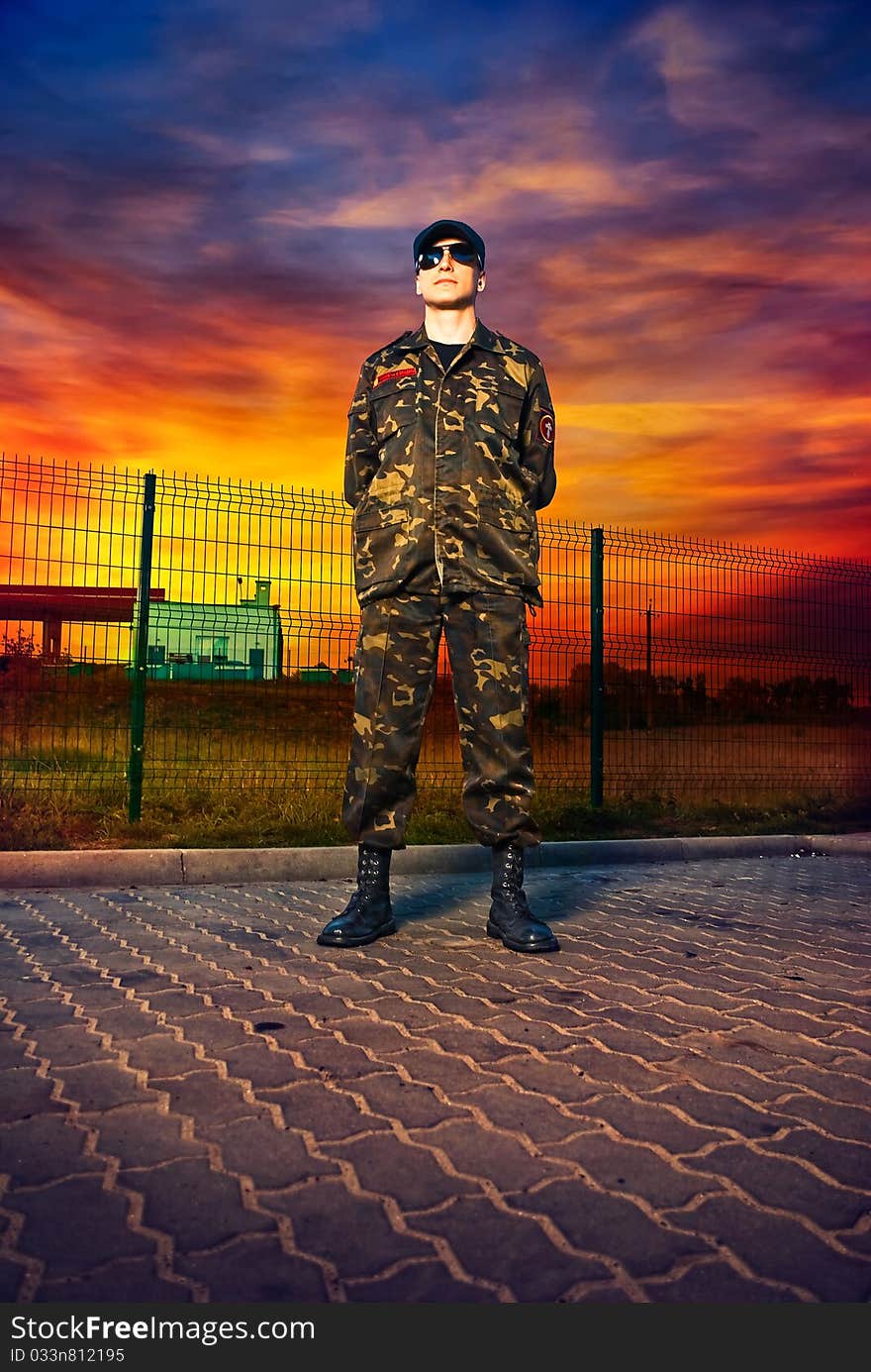 Man in camouflage at military base sunset. Man in camouflage at military base sunset