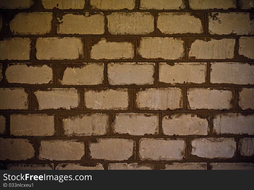 Very old brick wall covered with brown patina