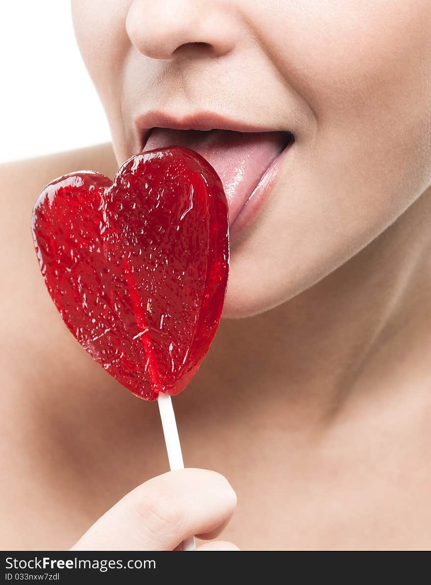 Closeup shot of girl with red heart lolipop isolated on white