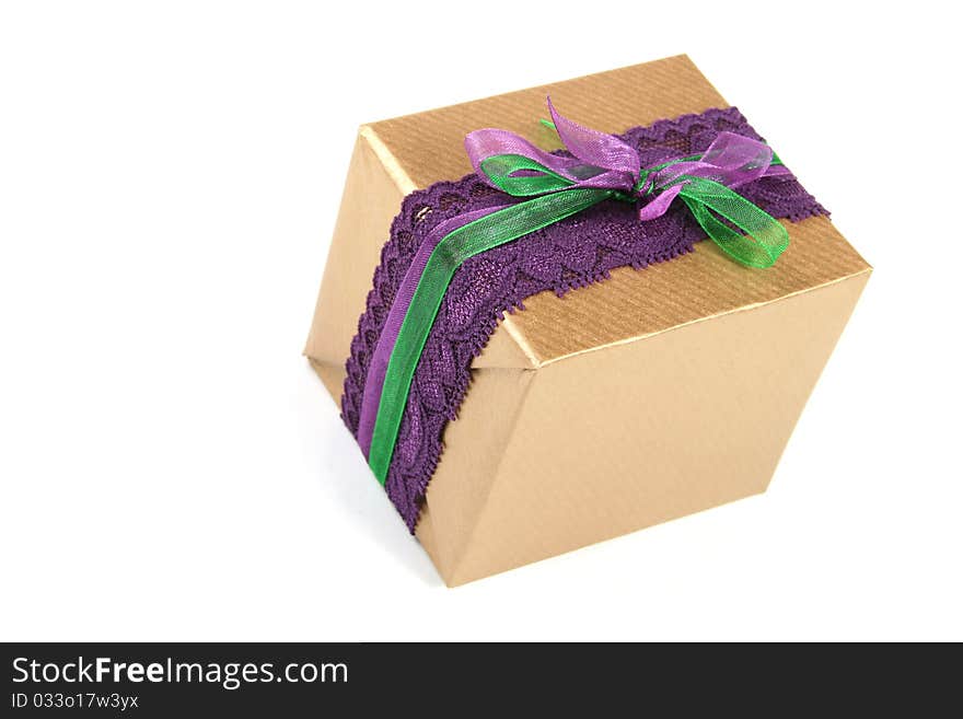 Gift box wrapped in golden paper and tied with purple lace