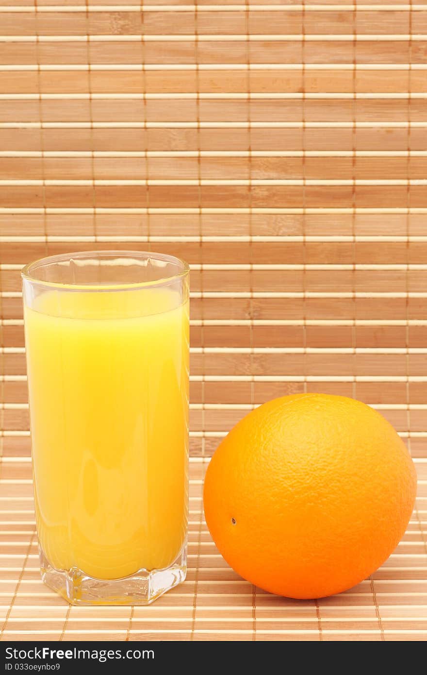 Orange juice in a glass and an orange