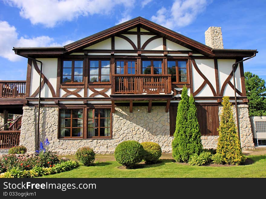 Cottage and small garden on a blue sky background. Cottage and small garden on a blue sky background