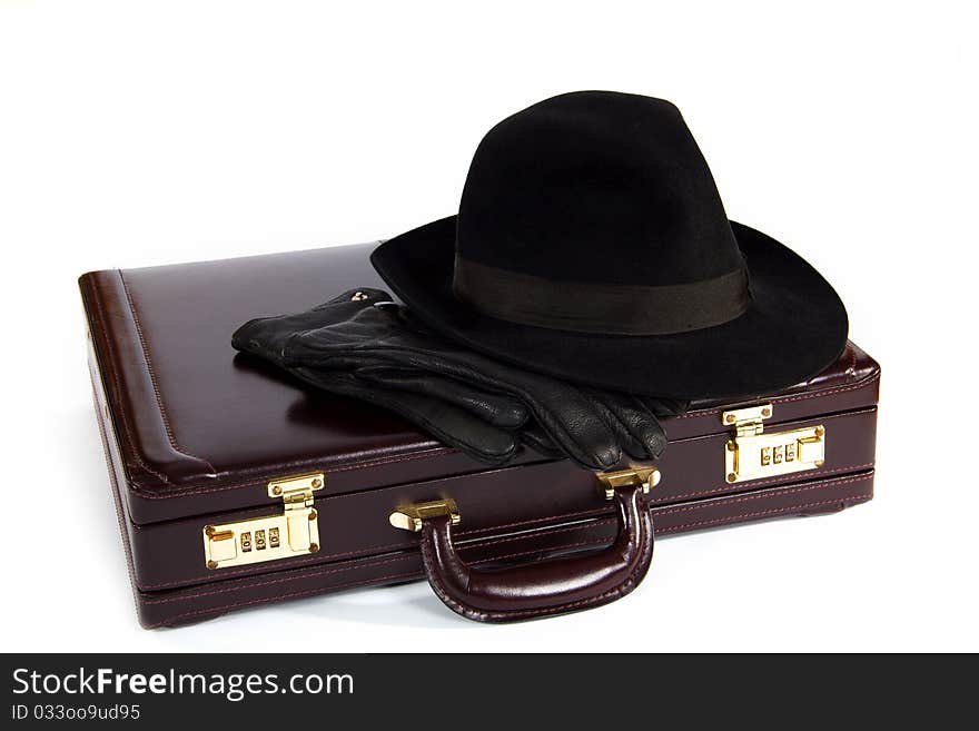 Suitcase with laying from above a hat and gloves on a white background