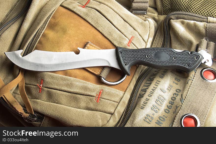 Army knife on a marching backpack background. Army knife on a marching backpack background