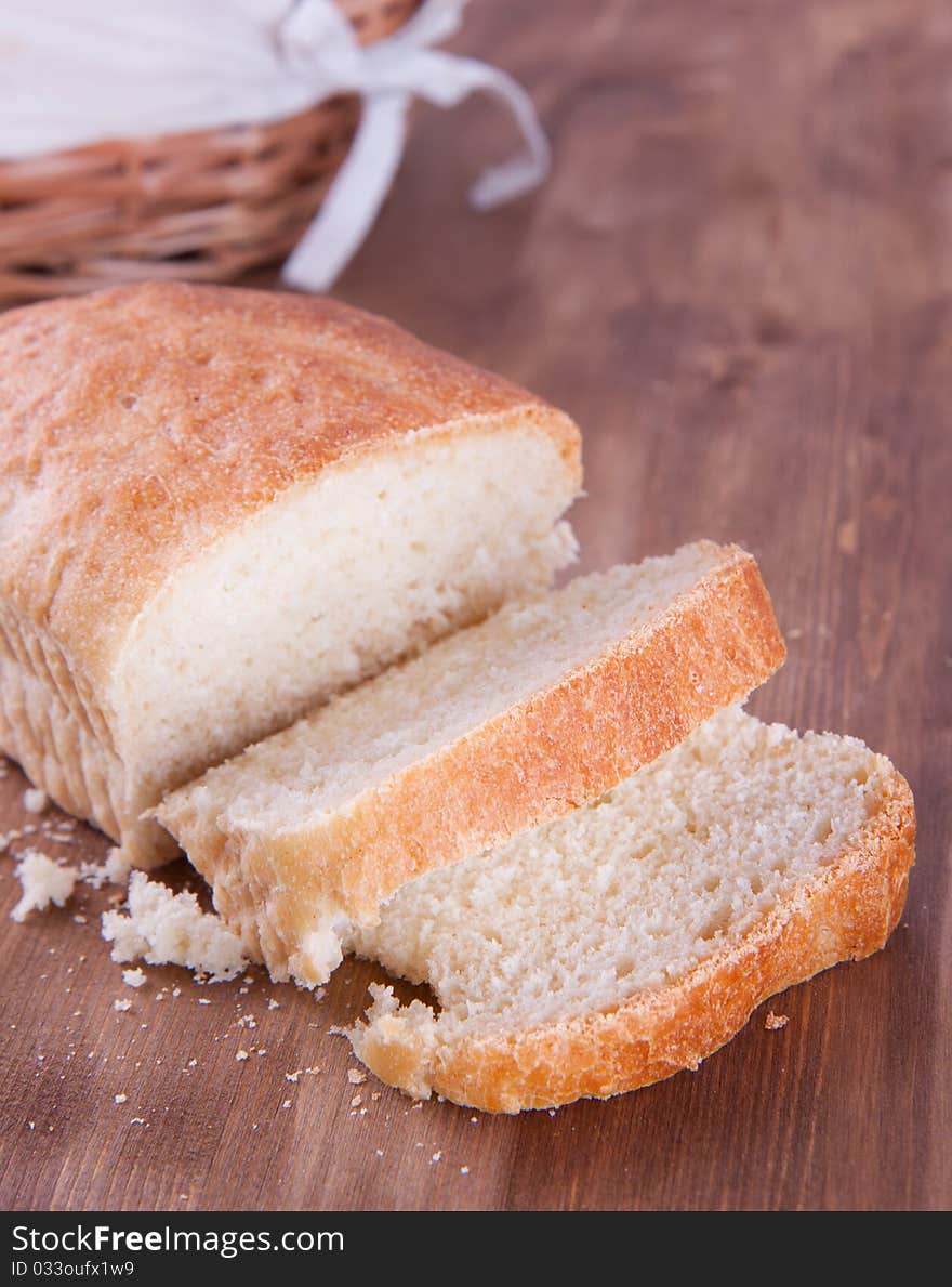 Sliced fresh cooking bread on the wooden table. Sliced fresh cooking bread on the wooden table