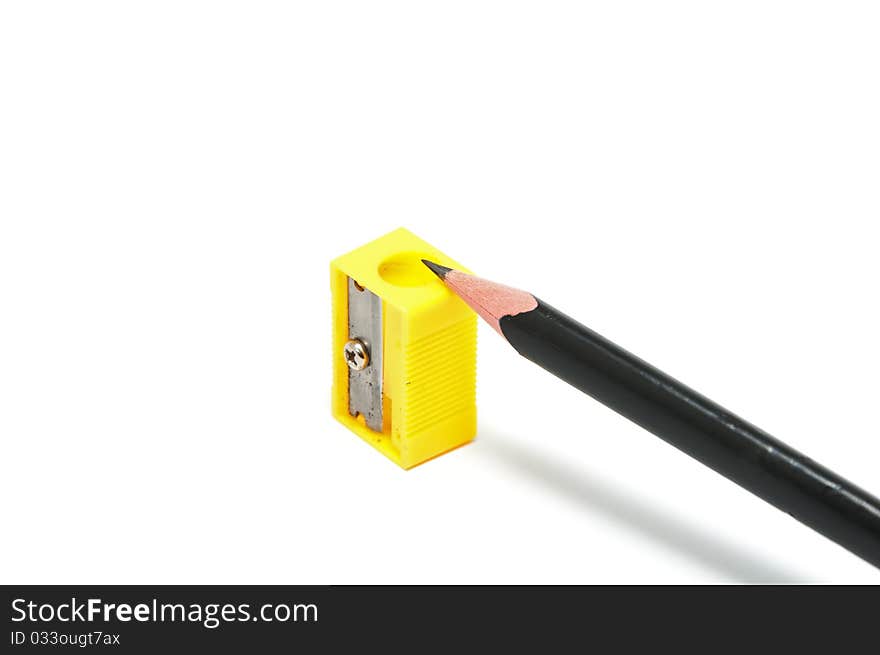 Yellow sharpener and black pencil on the white background