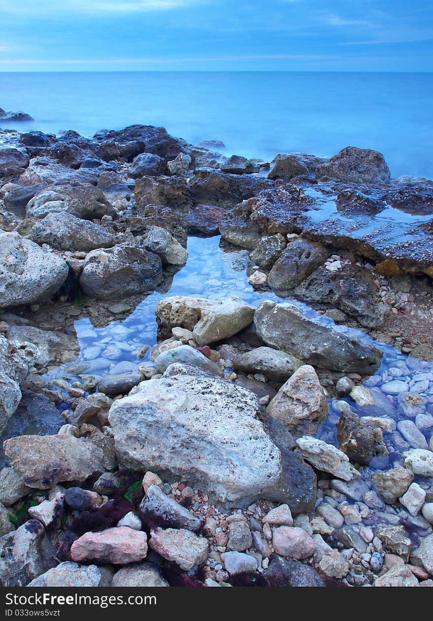 Stone and reflections in water during sundown