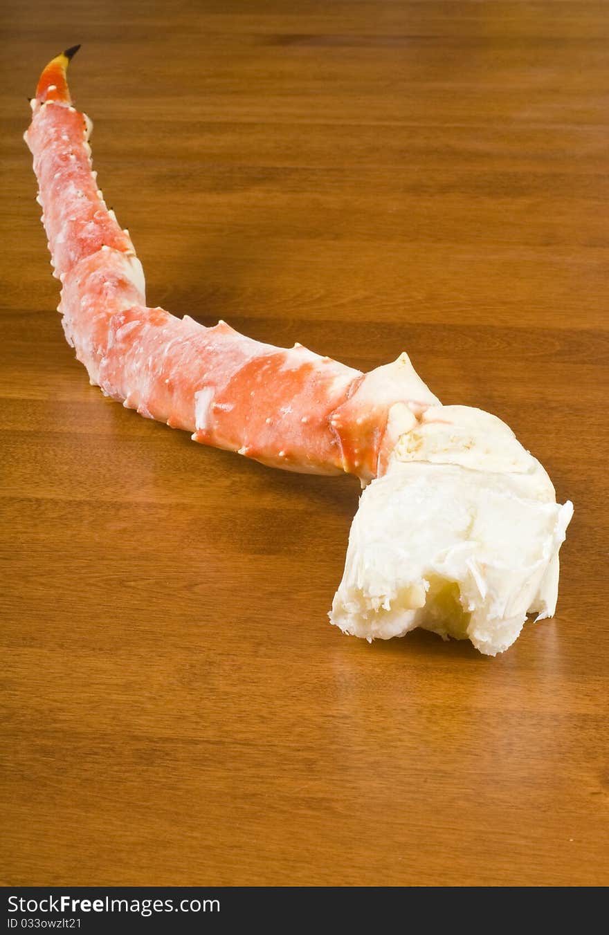 Pre-cooked frozen Alaskan King Crab leg on a table.