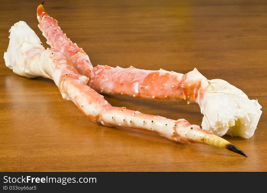 Pre-cooked frozen Alaskan King Crab legs on a table.