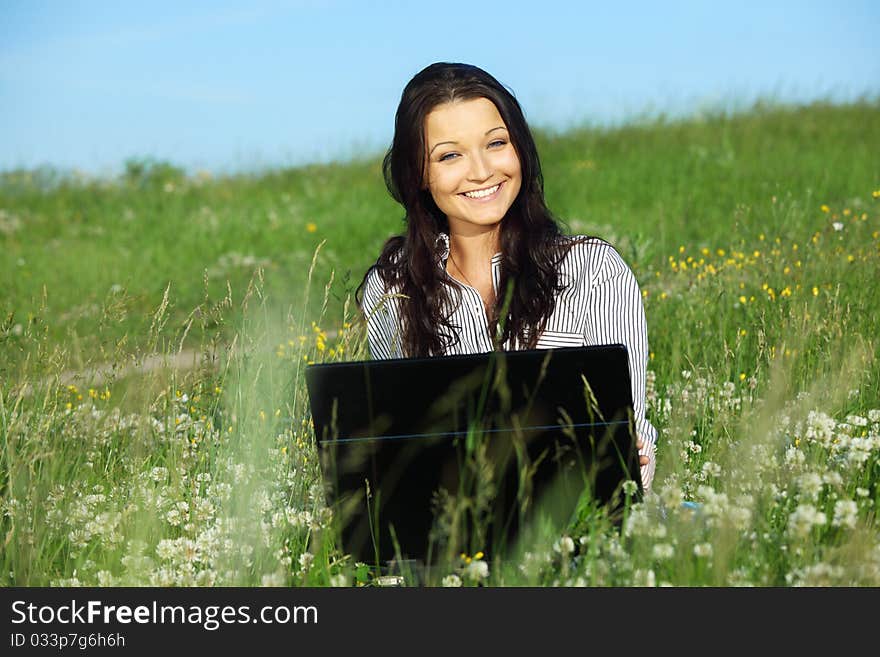 Woman on green field work on laptop. Woman on green field work on laptop