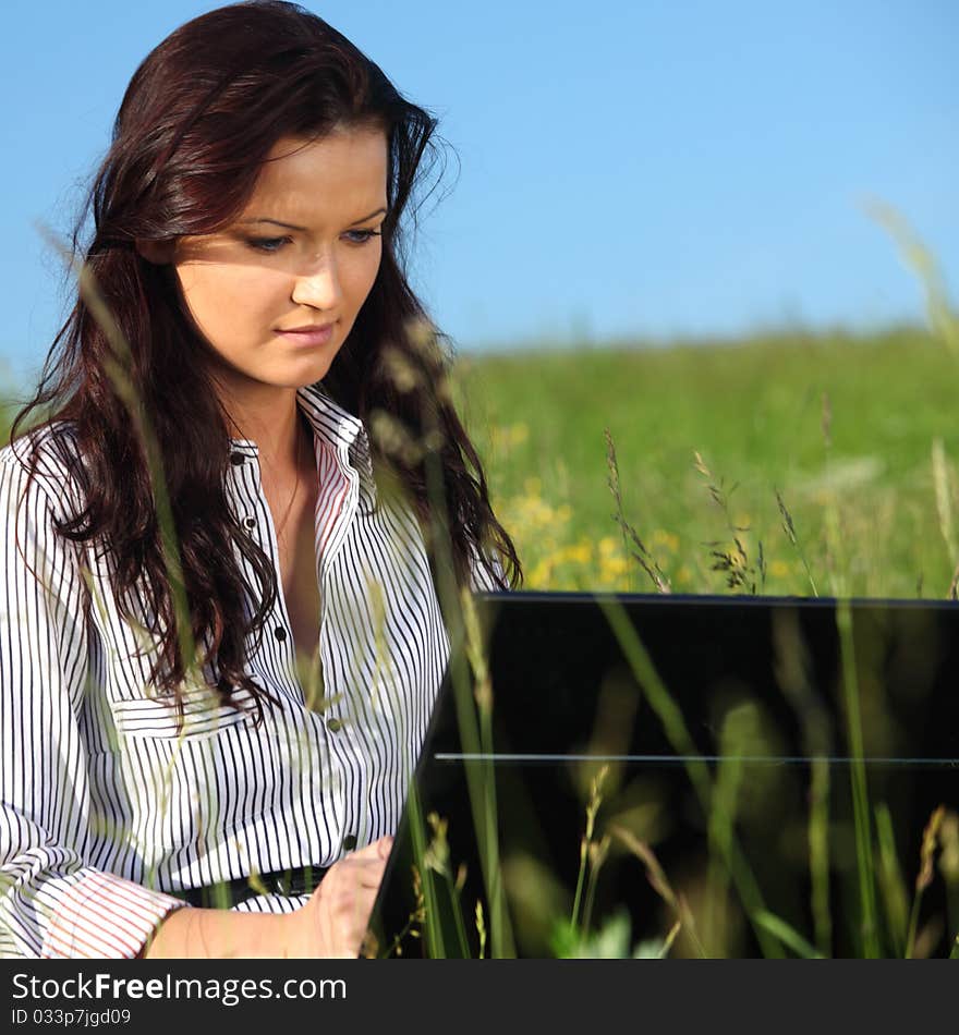 Woman on green field work on laptop. Woman on green field work on laptop