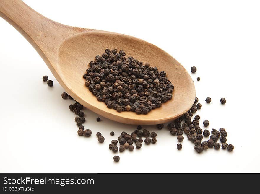 Peppercorns on wooden spoon