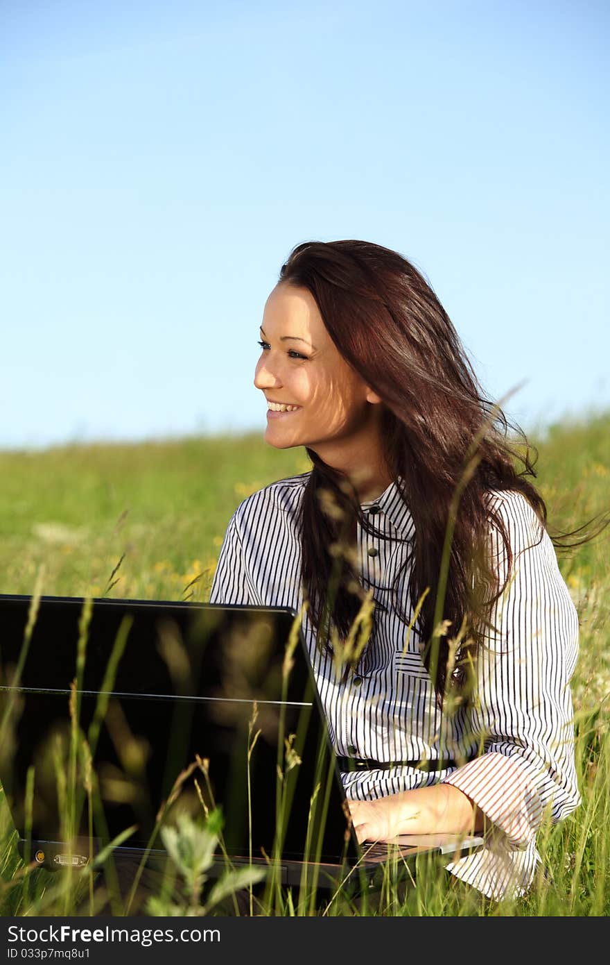 Woman on green field work on laptop. Woman on green field work on laptop