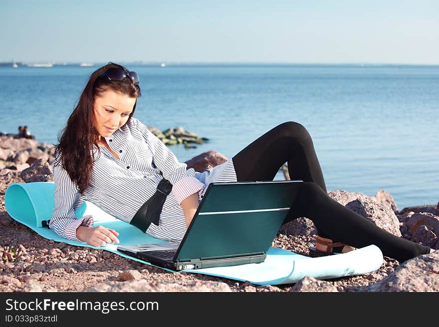 Woman work on laptop sea on background. Woman work on laptop sea on background