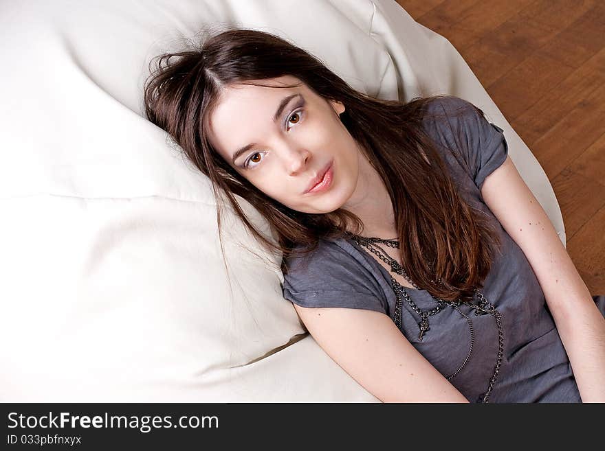 Beauty young woman with brown eyes lies on a pillow. Beauty young woman with brown eyes lies on a pillow