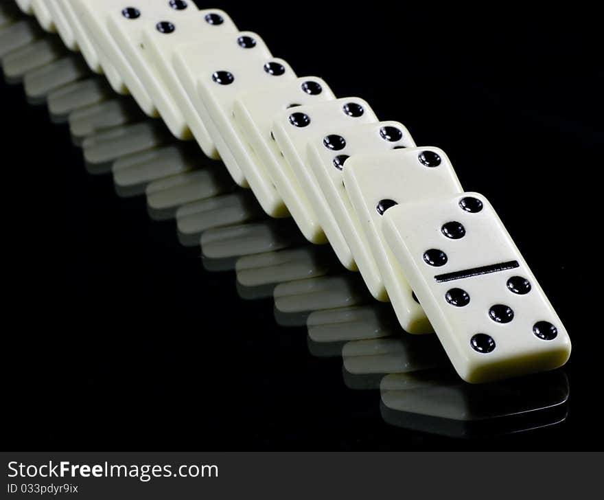 Toppled dominoes, white tiles on black background. Toppled dominoes, white tiles on black background.