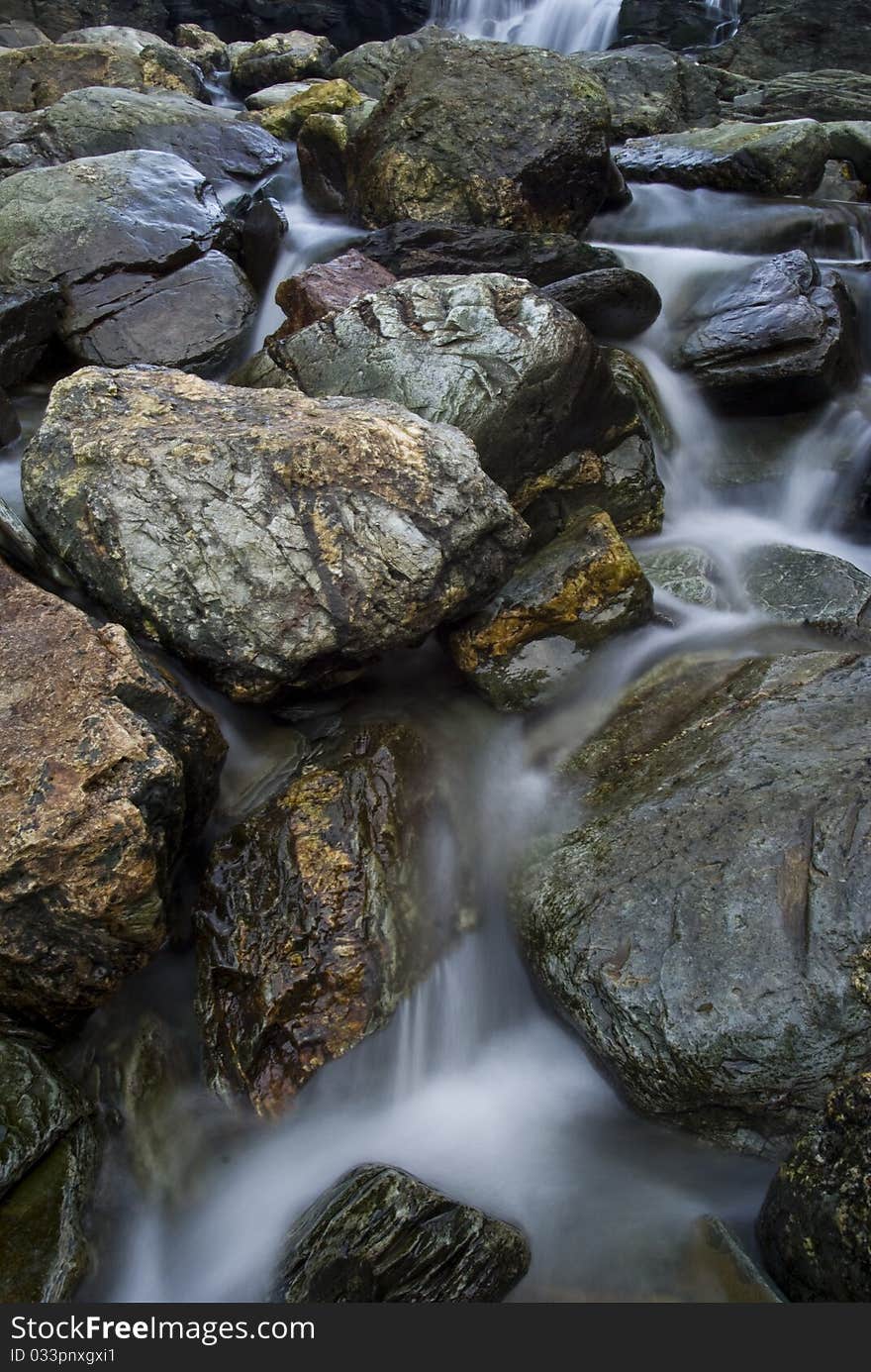 Bottom of the waterfall at Backways Cove on the north Cornwall coast near Tintagel, the stream flow over a diverse range of boulders. Bottom of the waterfall at Backways Cove on the north Cornwall coast near Tintagel, the stream flow over a diverse range of boulders