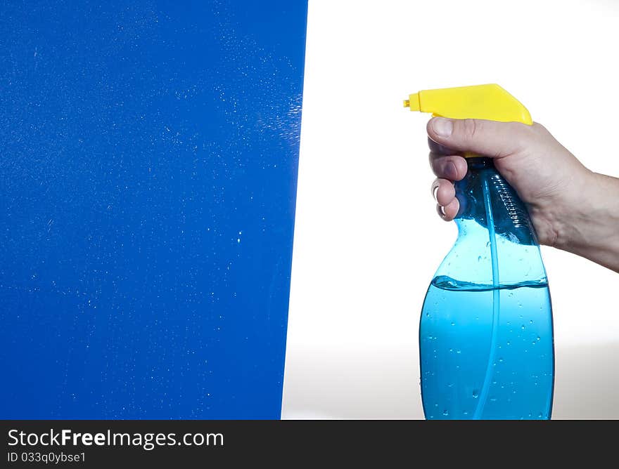 Hahd holding bottle of cleaning solution on the blue background