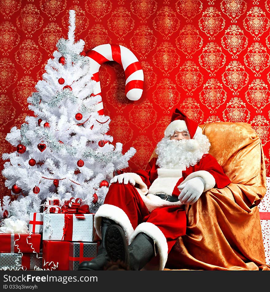 Santa Claus with presents and New Year tree at home. Christmas. Santa Claus with presents and New Year tree at home. Christmas.