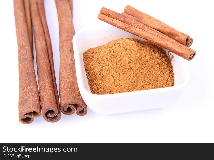 Cinnamon sticks and ground cinnamon on white background