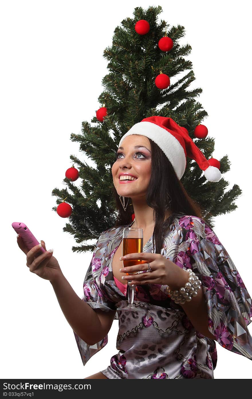 Woman speak mobile in front of a christmas tree