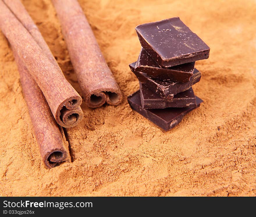 Chocolate pieces with cinnamon sticks and ground cinnamon. Chocolate pieces with cinnamon sticks and ground cinnamon