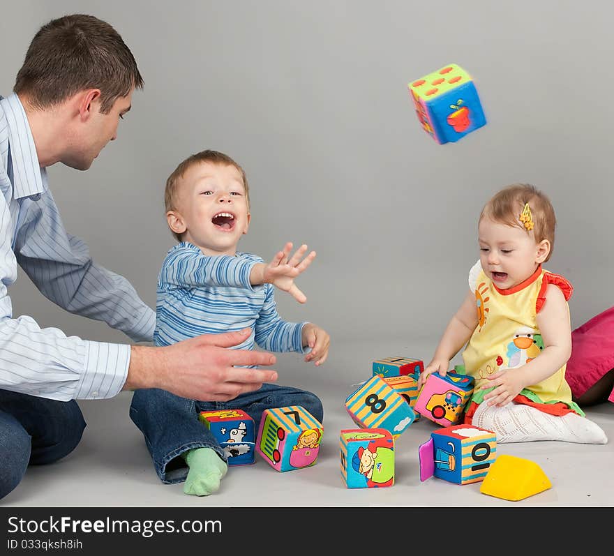 Father with children build house from cubes. Father with children build house from cubes