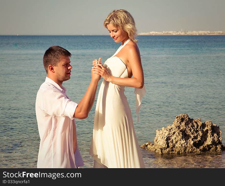 Groom wears ring bride on beach beautiful