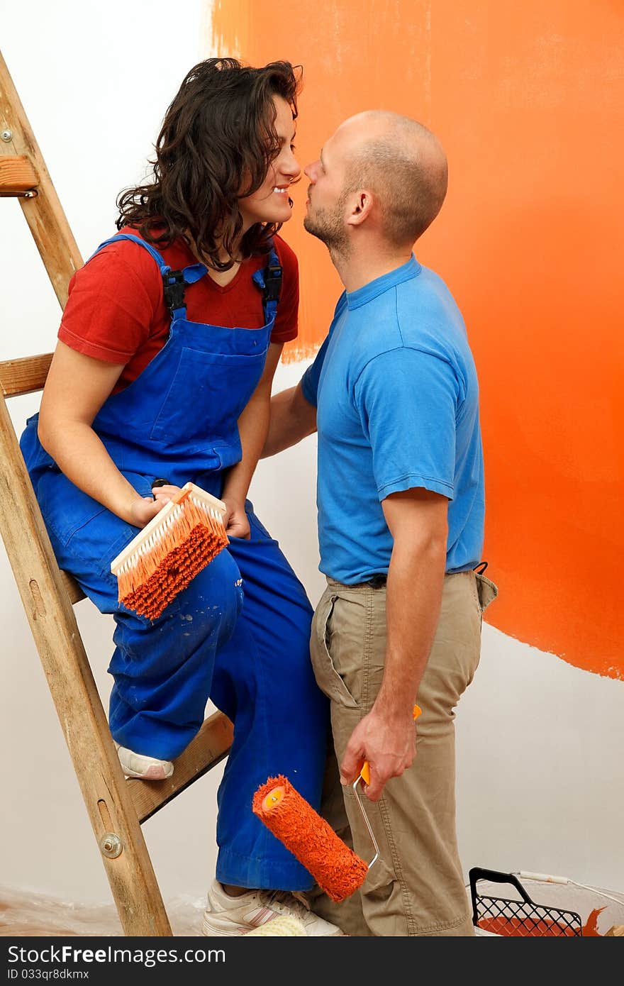 Romantic moments of a young pair during the wall painting. Romantic moments of a young pair during the wall painting