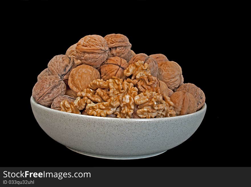 Walnut in ceramic bowl in isolated over black. Walnut in ceramic bowl in isolated over black