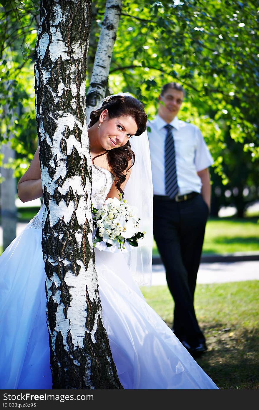 Happy bride and groom at the birches in the park