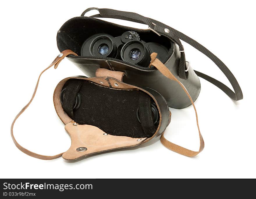 Old black binoculars in leather case on a white background