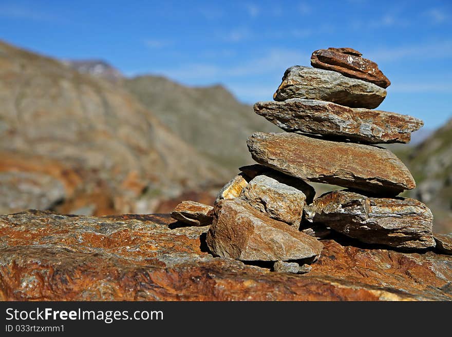 Stone sign along the Valle Umbrina track at 3140 meters on the sea-level. Brixia province, Lombardy region, Italy. Umbrina lake as background