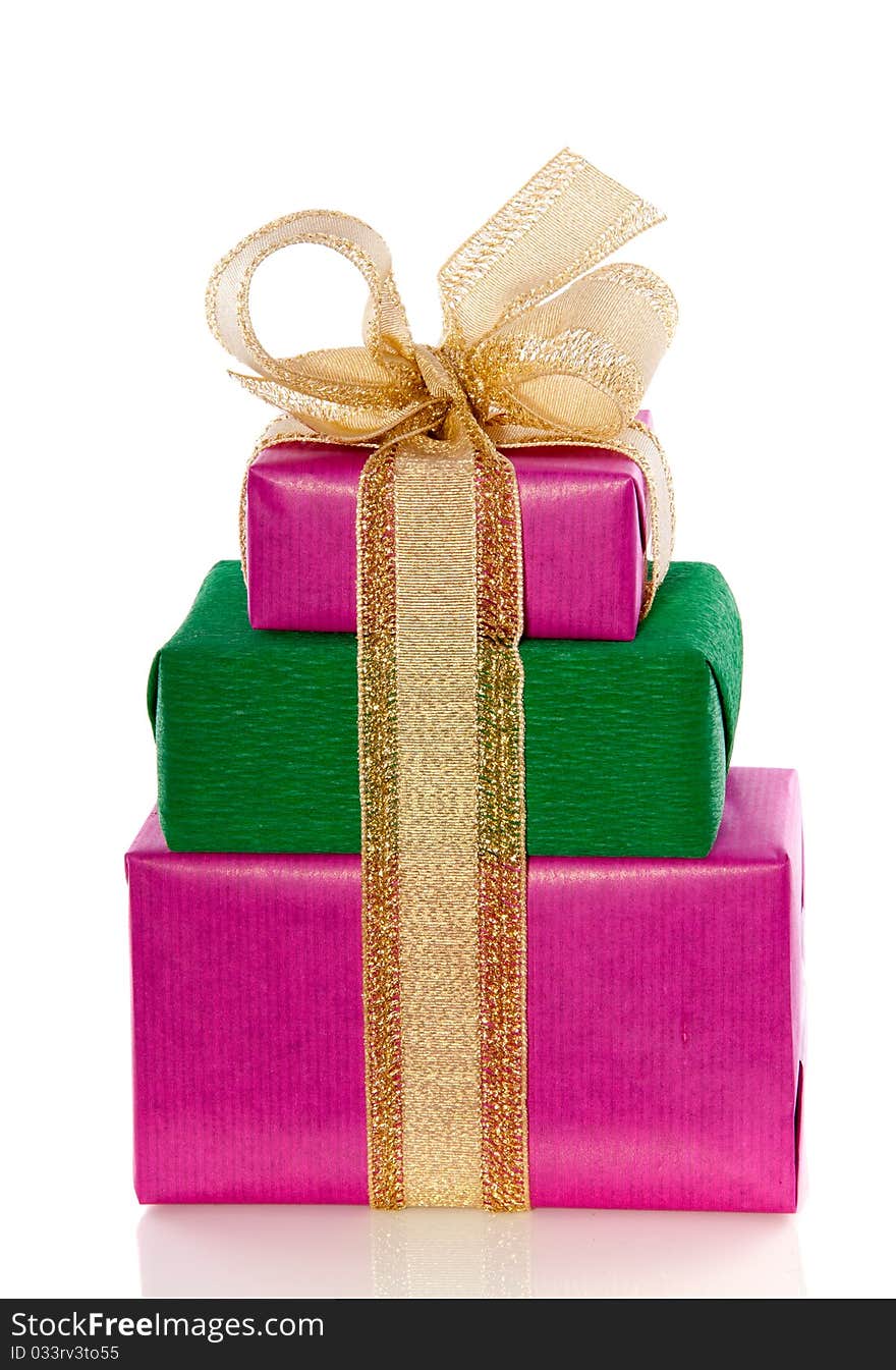 A pile of pink green gifts with a golden ribbon isolated over white