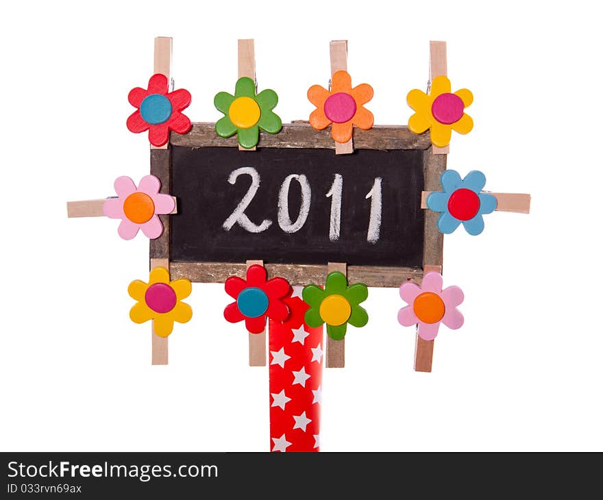 2011 written on a blackboard decorated with colorful wooden flowers isolated over white