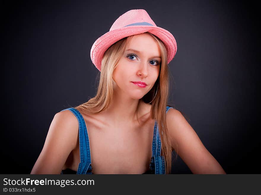 Pretty girl in pink hat and jeans overalls