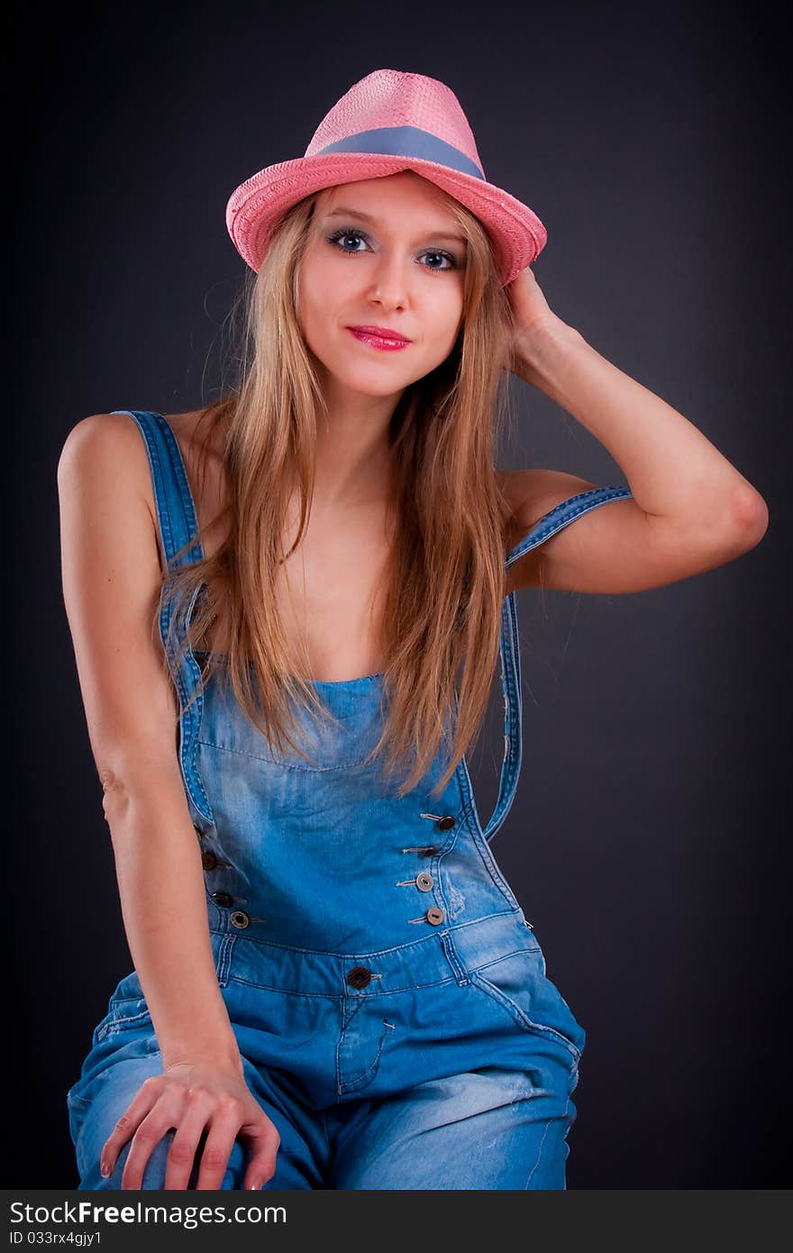 Pretty girl in pink hat and jeans overalls